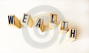 Word WEALTH. Wooden small cubes with letters isolated on white background with copy space available.