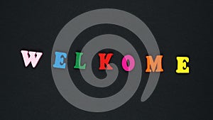 Word `welcome` with mistake formed of wooden multicolored letters. Colorful words loop.