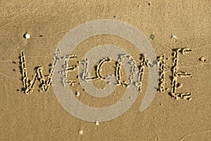 Word welcome written on the sand