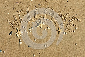 Word welcome written on the sand