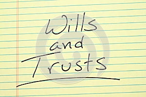 Wills and trusts on a yellow legal pad