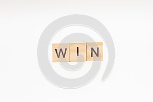 The word WIN is made of wooden cubes on a white background