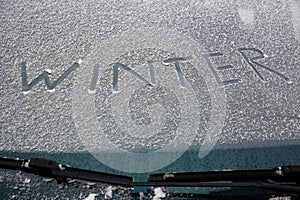 Word winter written on snowy windshield