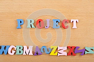 PROJECT word on wooden background composed from colorful abc alphabet block wooden letters, copy space for ad text. Learning