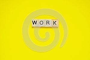 Word work. Top view of wooden blocks with letters on yellow surface