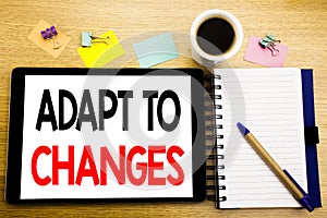 Word, writing Adapt To Changes. Business concept for Adaptation New Future Written on tablet laptop, wooden background with sticky