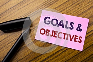 Word, writing Goals Objectives. Business concept for Plan Success Vision Written on sticky note red paper, wooden background with photo