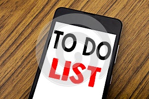 Word, writing handwriting To Do List. Business concept for Plan Lists Remider Written on mobile phone cellphone, wooden background photo
