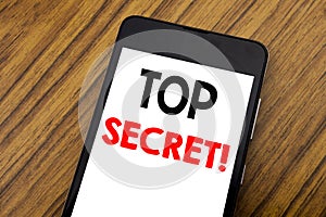 Word, writing handwriting Top Secret. Business concept for Military Top Secret Written on mobile phone cellphone, wooden backgroun