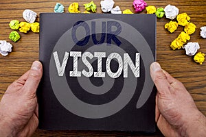 Word, writing Our Vision. Business concept for Marketing Strategy Vision written on notepad notebook book on the wooden wood backg