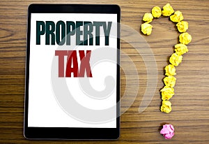 Word, writing Property Tax. Business concept for Estate Income Taxation Written on tablet, wooden background with question mark on