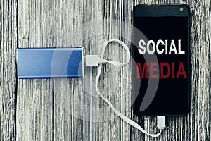 Word, writing Social Media. Business concept for Community Social Media written on mobile cell phone mobile and power-bank charger