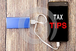 Word, writing Tax Tips. Business concept for Taxpayer Assistance Refund Reimbursement written on mobile cell phone mobile and powe