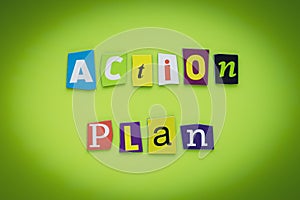 A word writing text - action plan. Cut colorful letters on a yellow and green background. Headline on banner. Inscription. Plannin