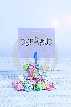 Word writing text Defraud. Business concept for to trick or cheat someone or something in order to get money Reminder pile colored photo