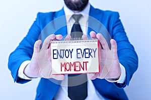 Word writing text Enjoy Every Moment. Business concept for being pleased with your life Have fun Precious time Man holds