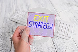 Word writing text Exit Strategy. Business concept for Extricating oneself from a situation that is become difficult man holding photo