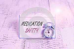 Word writing text Medication Safety. Business concept for freedom from preventable harm with medication use Mini blue alarm clock