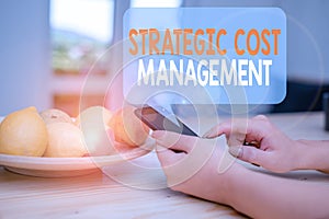 Word writing text Strategic Cost Management. Business concept for Reduce total Expenses while improving operation woman