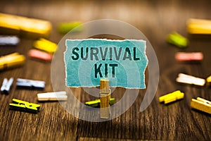 Word writing text Survival Kit. Business concept for Emergency Equipment Collection of items to help someone Clothespin holding bl photo