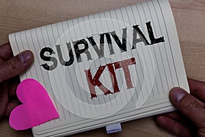 Word writing text Survival Kit. Business concept for Emergency Equipment Collection of items to help someone Man holding notebook