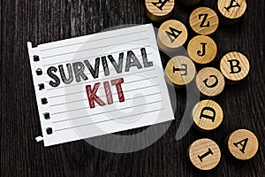 Word writing text Survival Kit. Business concept for Emergency Equipment Collection of items to help someone Piece notebook paper