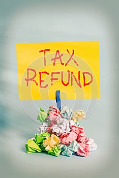 Word writing text Tax Refund. Business concept for refund on tax when the tax liability is less than the tax paid Reminder pile