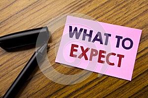 Word, writing What To Expect. Business concept for Achieve Expectation Written on sticky note red paper, wooden background with pe