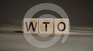 Word WTO - World Trade Organization, made with wood building blocks on black and gray background