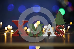 The word XMAS on a background of beautiful bokeh