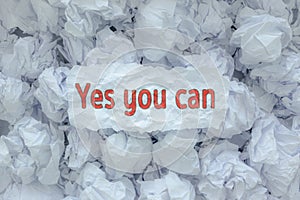 The word YES WE CAN is placed on the background paper in the big trash