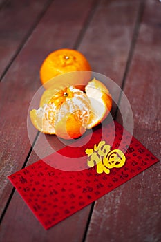 Wording of happiness on the red packet with tangerines.