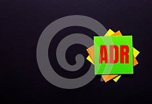 The words ADR Alternative Dispute Resolution on a bright sticker on a dark background. Copy space