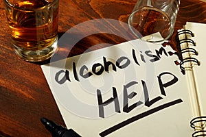 Words alcoholism HELP written on a paper.