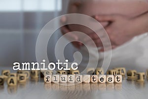 Words AMNIOTIC FLUID TEST composed of wooden letters