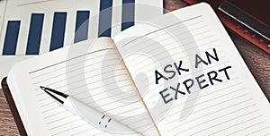 The words ask an expert written on a white notebook