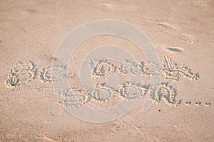 The Words `Be Back Soon` Written in the Sand