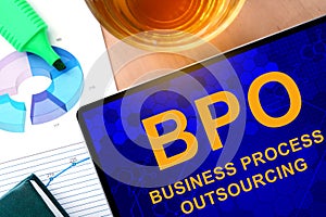 Words Business Process Outsourcing BPO on the tablet and charts.