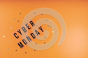 Words CYBER MONDAY on a bright orange sequined background