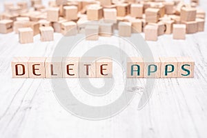 The Words Delete Apps Formed By Wooden Blocks On A White Table