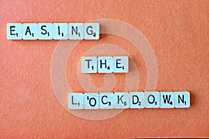 The words - Easing the lockdown - spelt out on amber with copy space