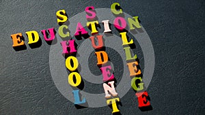 The words Education, School, Student, College built of colorful wooden letters on a dark table.