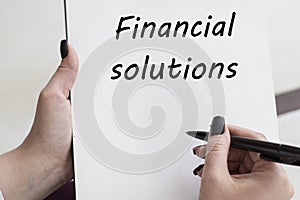 Words FINANCIAL SOLUTIONS writes girl on a blank white sheet