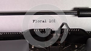 The words `Floral 101 ` being typed on a typewriter