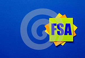 The words FSA Flexible Spending Account is written on bright stickers on a blue background