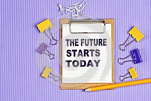 The words The future starts today written on a white notebook