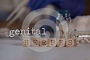 Words GENITAL HERPES composed of wooden dices. Pills, documents and a pen in the background photo