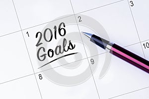The words 2016 Goals on a calendar planner to remind you an important appointment with a pen on isolated white background. New Ye