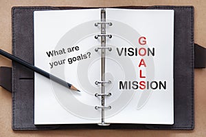 Words of goals, vision and mission on organizer book with pencil