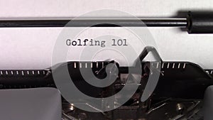 The words `Golfing 101 ` being typed on a typewriter